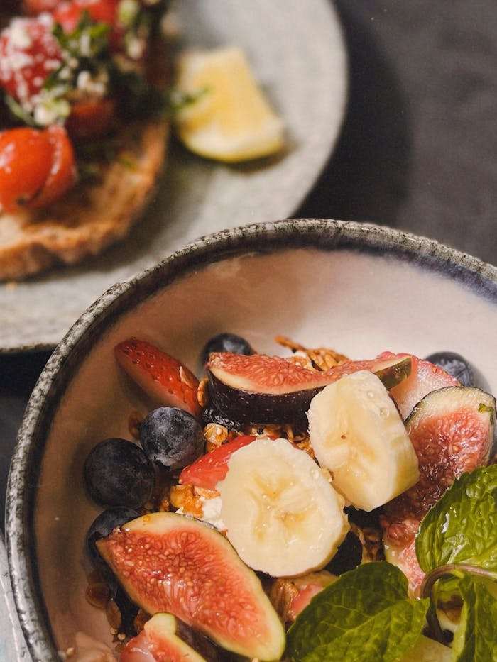 Delicious breakfast setup with a fresh fruit salad and bruschetta for a healthy start.